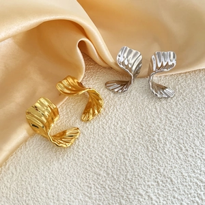 Detailed view of 18K gold plated earrings with irregular twisted texture on silk fabric