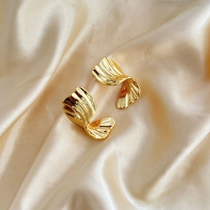 Macro shot of 18K gold plated earrings with irregular textured wavy ripple design