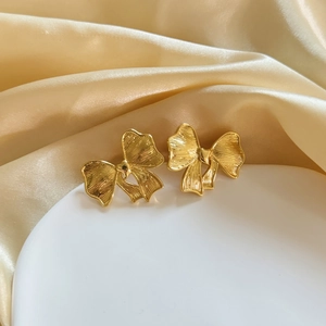 18K gold plated bow stud earrings with textured finish on a white plate background