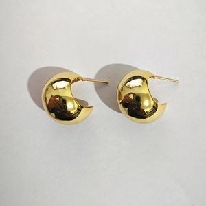 Detailed close-up of C-shaped polished 18k gold plated drop earrings on white background