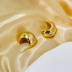 Close-up of 18K gold-plated C-shaped chunky hoop earrings on elegant silk background