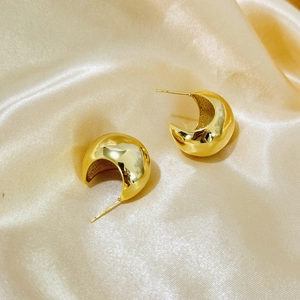 Polished 18K gold-plated C-shaped chunky hoop earrings on champagne satin backdrop
