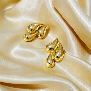 Gold-plated 18K geometric triple-layer teardrop earrings on elegant champagne silk fabric