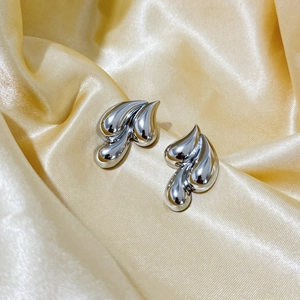Three-layer silver geometric water drop earrings on luxury champagne satin background