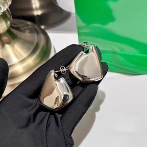 Macro shot of silver geometric irregular earrings with high-polish mirror finish