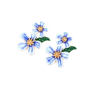 Detail of blue and white enamel flower earrings with golden core and green leaf