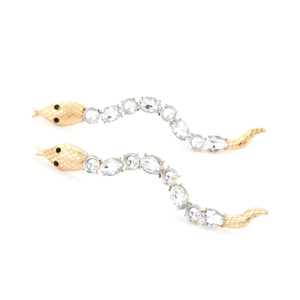 Macro shot of long snake earrings with gold plating and faceted crystal stones