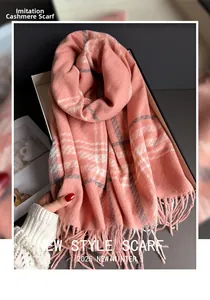 Close-up of pink plaid cashmere-like scarf showing soft texture and fine fringe details