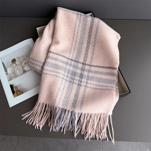 Detailed view of pink and grey plaid scarf featuring soft brushed texture and fringe trim