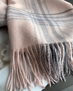 Close-up of pink and grey plaid scarf featuring soft cashmere-like texture and long fringes