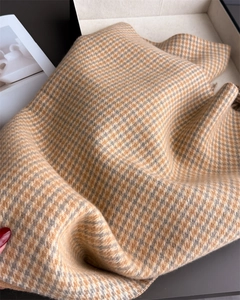 Gros plan sur la texture douce en cachemire pied-de-poule avec un tissage marron et gris