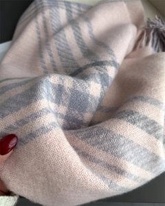 Detail of soft plaid scarf with tassels in light pink and grey-blue checkered pattern