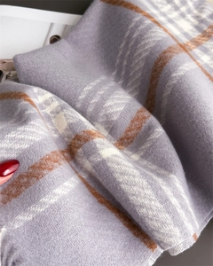 Close-up of soft plaid scarf showing lavender and beige textured cashmere-like fabric