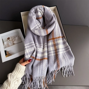 Detail shot of soft plaid tassel scarf in grey and orange cashmere-like texture