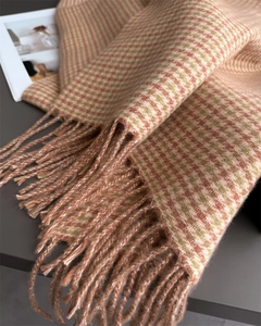 Détail d'une écharpe à carreaux pied-de-poule orange et vert avec de longues franges