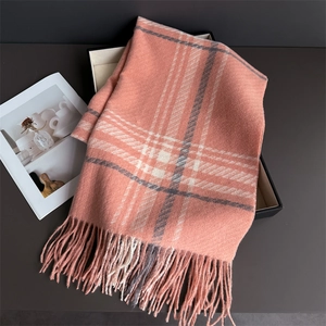 Close-up of peach plaid scarf showing soft tassels and warm brushed cashmere texture