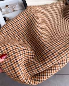 Gros plan du tissu d'écharpe à carreaux marron et blanc avec texture cachemire et franges
