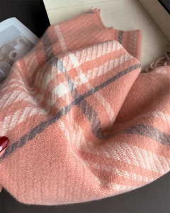 Close-up of pink and white plaid cashmere scarf showing soft texture and tassel details