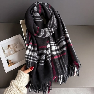 Detailed view of black and white plaid scarf with red accents and soft fringe edges