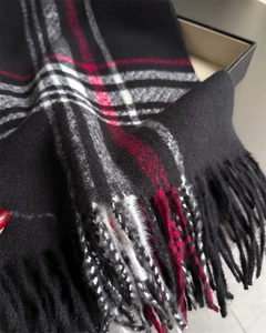 Close-up of classic plaid cashmere-like scarf showing texture and fringe tassels detail