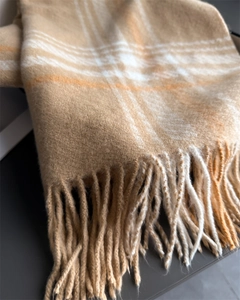 Close-up of classic plaid scarf with soft cashmere-like texture and neat tassel details