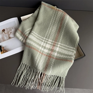 Detailed view of sage green plaid scarf texture and fringe in a premium gift box