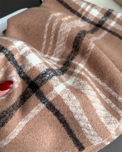 Close-up of thick plaid cashmere scarf showing soft texture and premium warm fabric