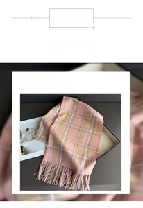 Detailed close-up of pink and yellow plaid scarf featuring soft fringe and smooth texture