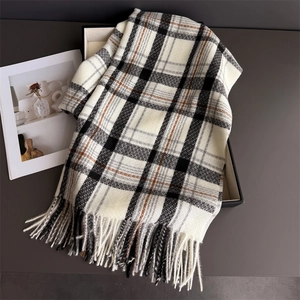Macro detail of plaid scarf showing soft texture and dense fringe trim