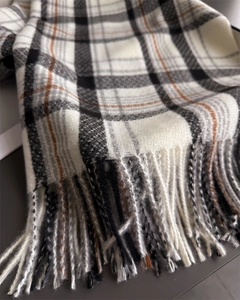 Close-up of vintage plaid cashmere-feel scarf with detailed soft fringe and woven texture