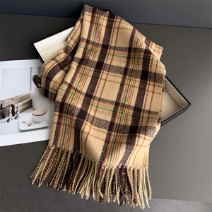 Close-up of vintage plaid scarf with camel and brown stripes and long tassel edge