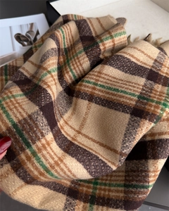 Detailed view of classic plaid scarf texture with soft fringe and warm cashmere feel