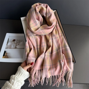 Pink and grey plaid cashmere-like scarf with tassels shown on a minimalist background