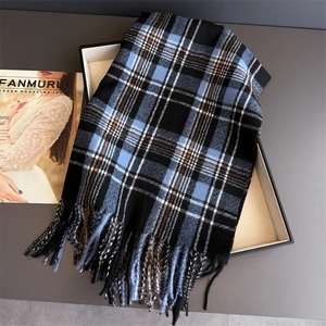 Close-up of sky blue plaid cashmere scarf with long tassels in luxury gift box