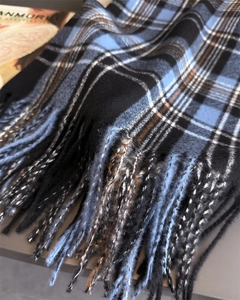 Close-up of blue and black plaid scarf with thick fringe and soft cashmere texture