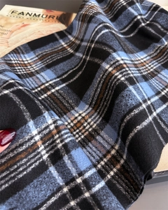 Close-up of thick blue and black plaid scarf texture with soft brushed cashmere finish