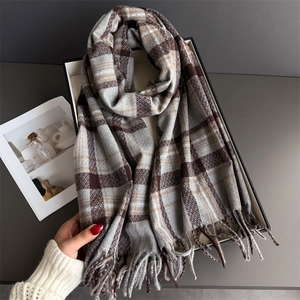 Close-up of thick plaid scarf showing soft tassels and cozy cashmere-like texture