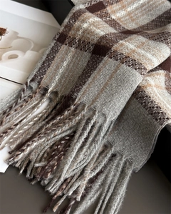 Macro detail of plaid cashmere-like scarf with soft texture and long fringe tassels