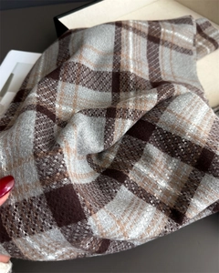 Close-up of soft plaid scarf fabric with brown and grey checks and fringe detail