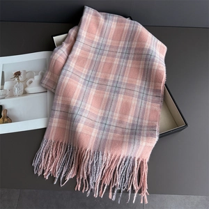 Detail of pink and grey plaid scarf with soft fringe edges and cashmere-like texture