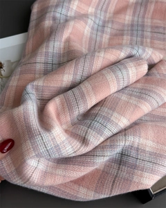 Close-up of soft plaid scarf fabric showing pink and grey cashmere texture