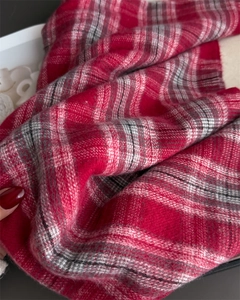 Macro view of plaid cashmere scarf fabric showing red check pattern and soft texture