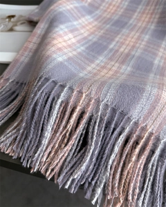 Close-up of soft plaid scarf fabric in purple and pink with delicate fringe detail