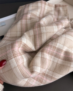 Close-up of beige and brown plaid cashmere-like scarf showing fine texture and tassels