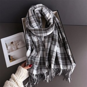 Macro detail of classic black and white plaid scarf fabric with soft fringe edges
