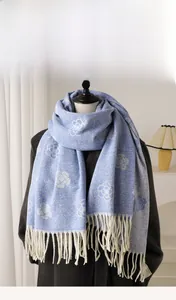 Detail of blue imitation cashmere scarf with white camellia flowers and tassels