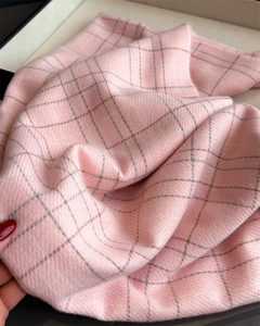 Close-up of pink and grey plaid scarf showing fine twill weave and soft cashmere texture
