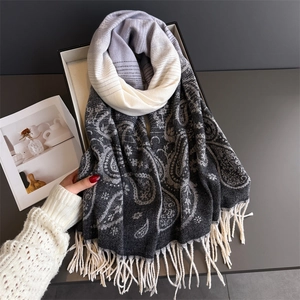 Detail of paisley pattern and tassels on gray gradient cashmere blend scarf