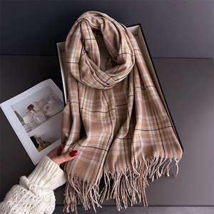 Detailed view of British plaid scarf with tassels in a minimalist white gift box
