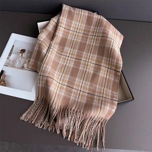 Detailed texture of camel plaid scarf with elegant tassels on a minimalist background